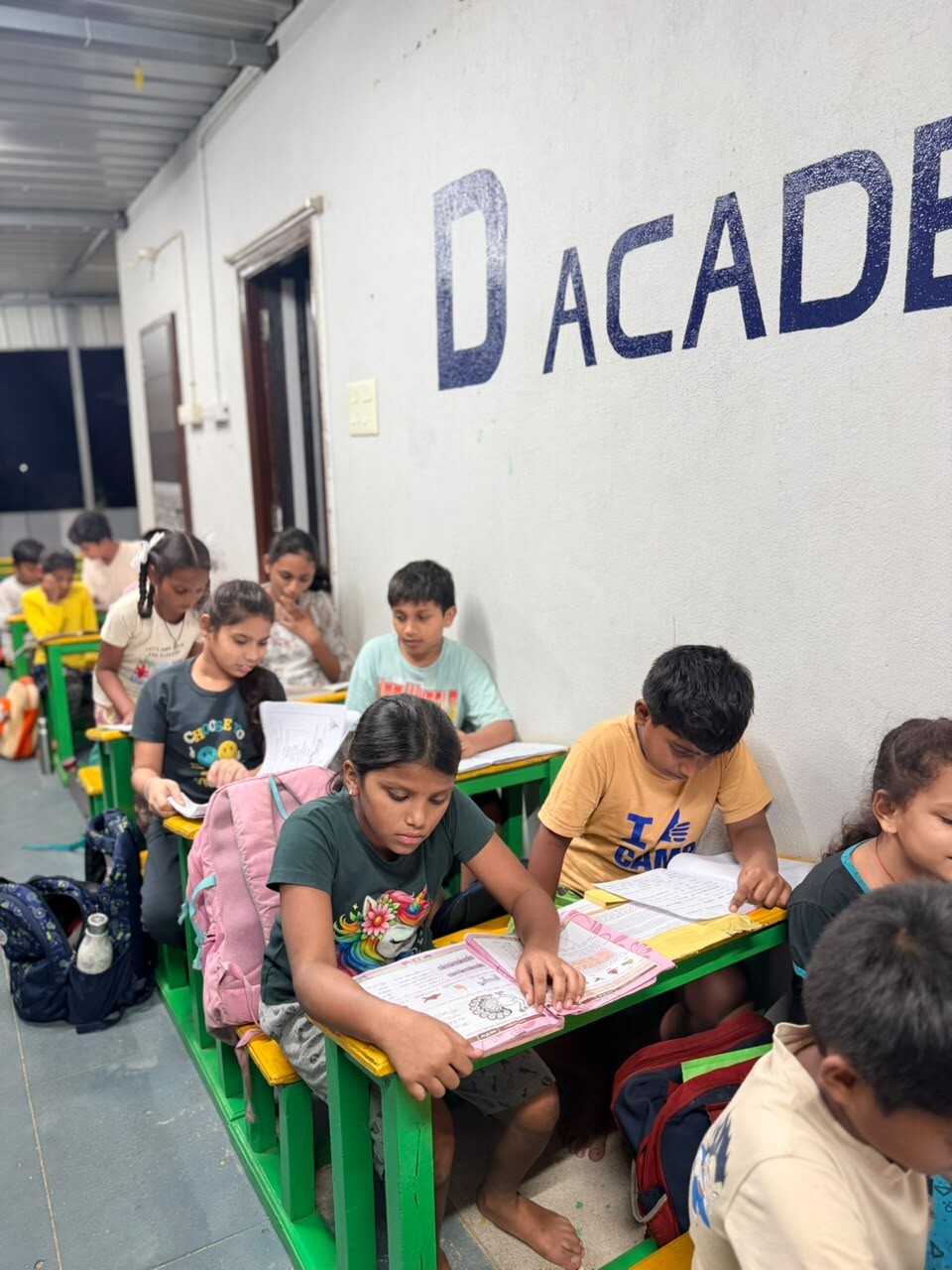 D Academy students learning together in class at green and yellow desks